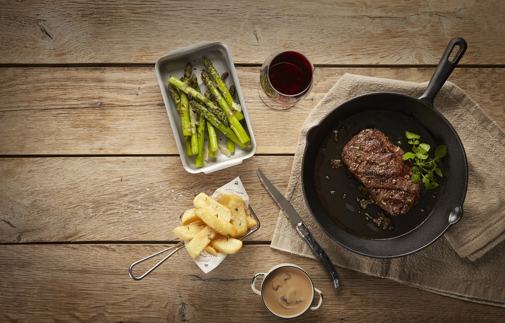 Close up of steak, chips, asparagus and glass of wine