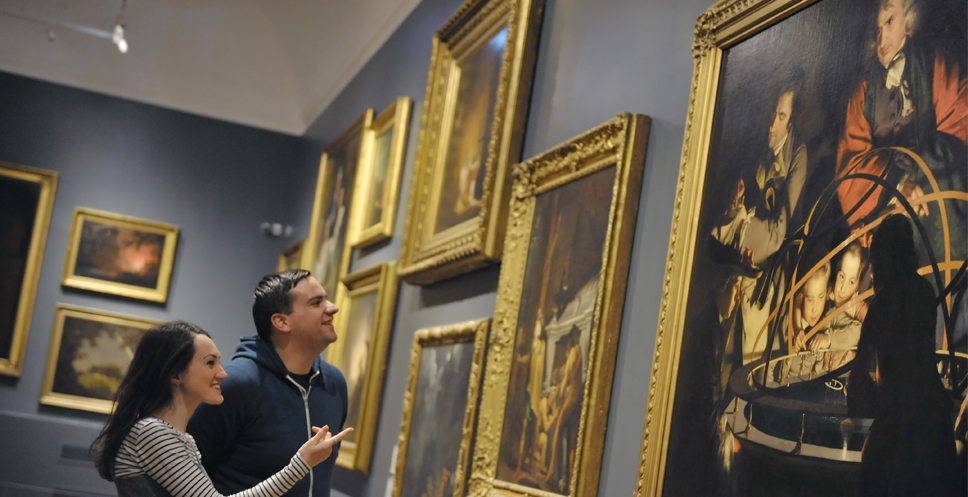 Visitors looking at Joseph Wright paintings