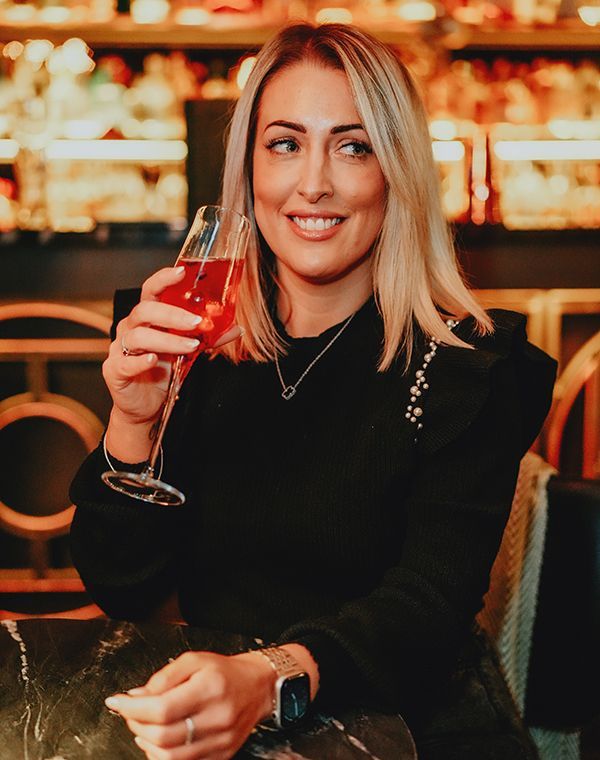 A young blonde woman enjoying a cocktail