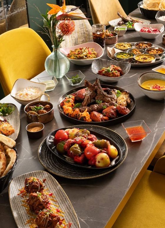 A vast array of Indian food laid out on a table in many dishes