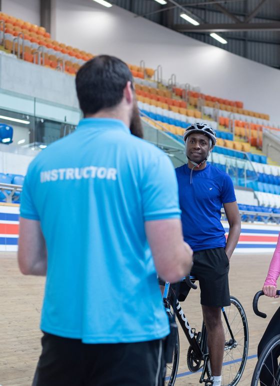 Cycling instructor in Derby Arena talking to a man on a bike